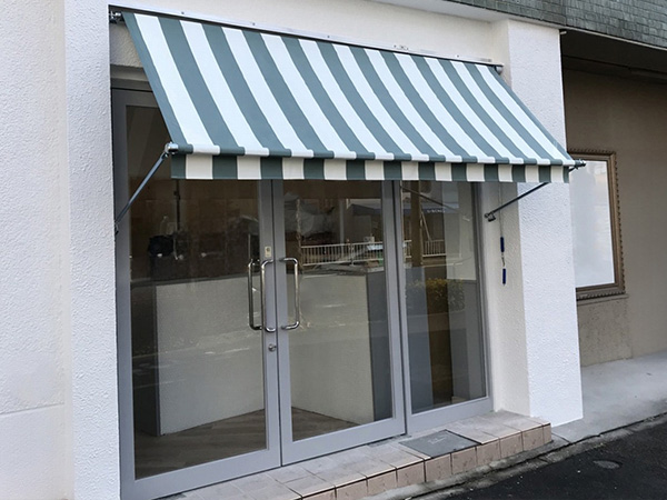 店舗入り口に取り付けられたストライプ柄の巻き上げテント