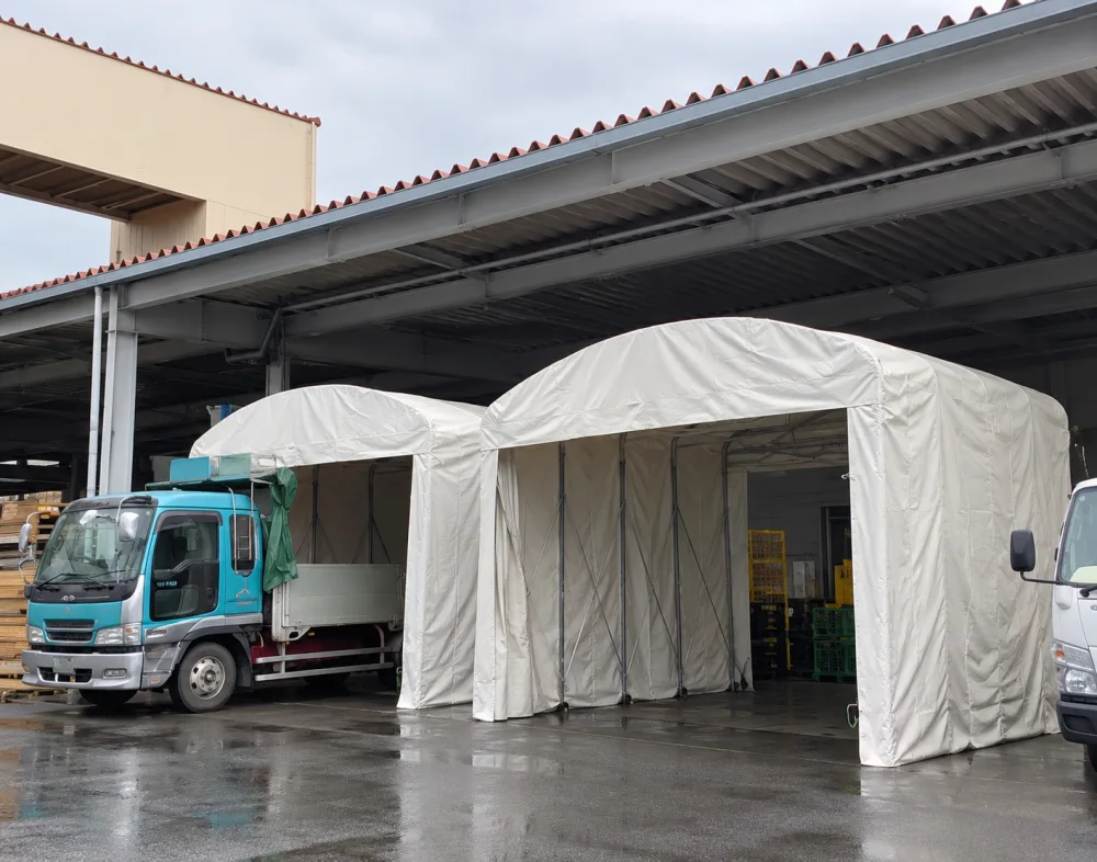 トラックの荷台を覆うアーチ型のキャスター式伸縮テント