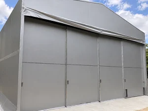 テント倉庫の正面に並べたグレーのシートドアと傾斜した屋根