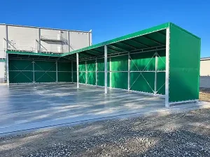 荷捌きテントの屋根を支える鉄骨と前面の開放的な開口部