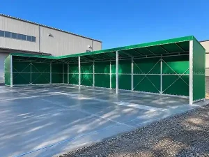 前面を広く開放した荷捌きテントの全景とグリーンの屋根・側面シート